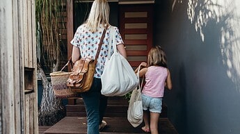 mare i filla pujan escales agafant bossa de tela reutilitzable